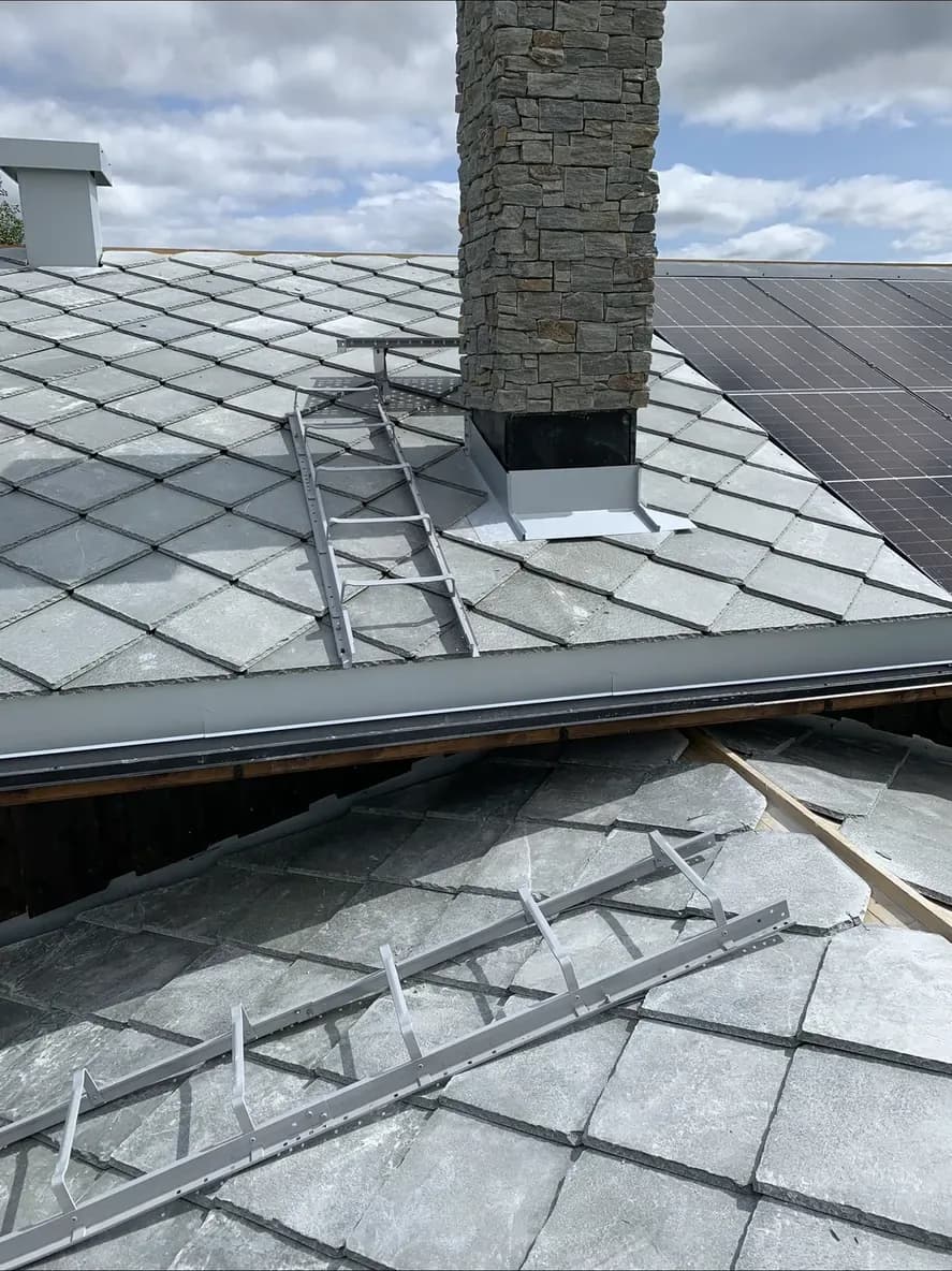 Skifertak med steinpipe og solcellepanel